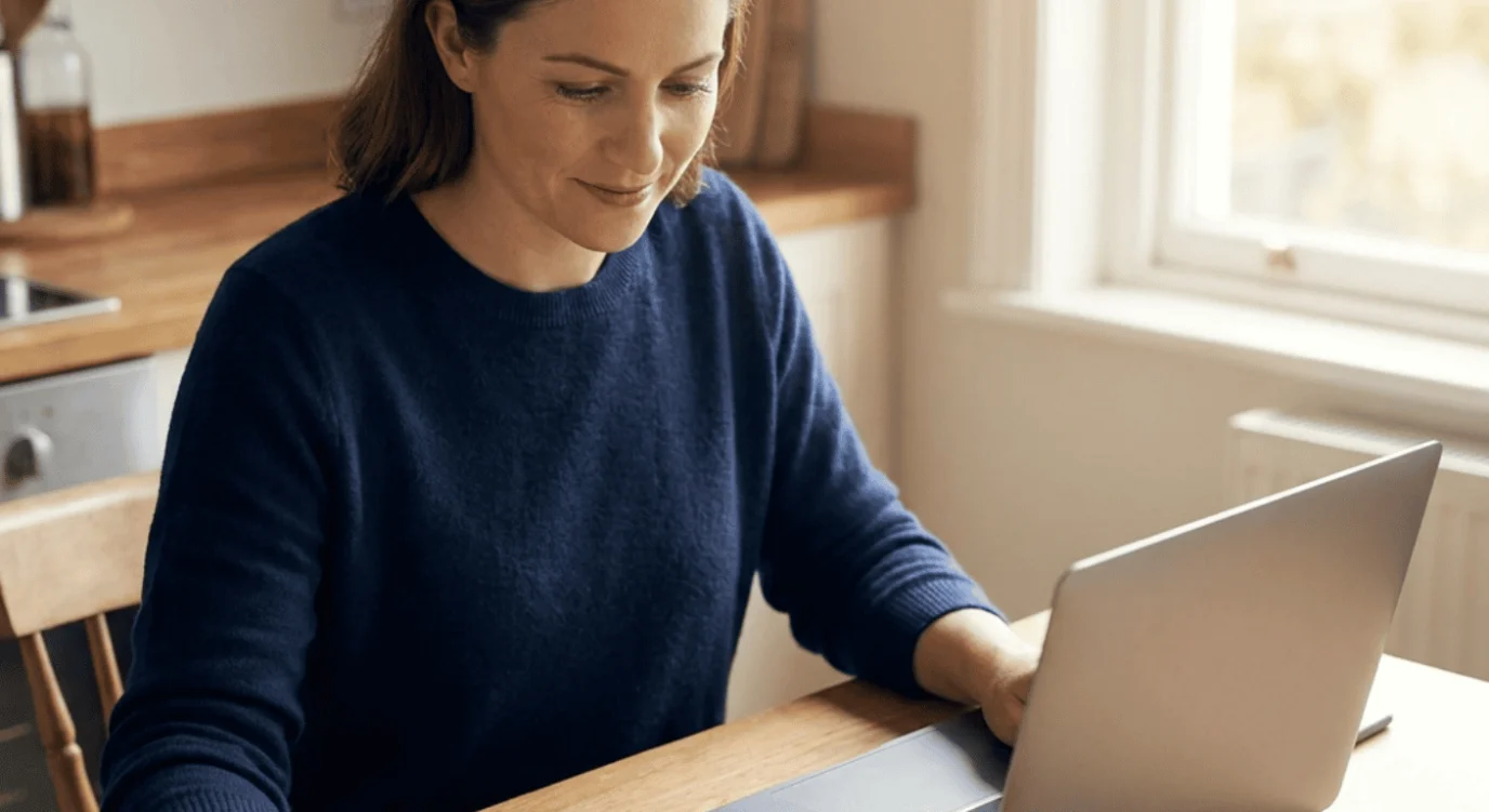 Saver planning a CD ladder at a kitchen table with a laptop and notebook